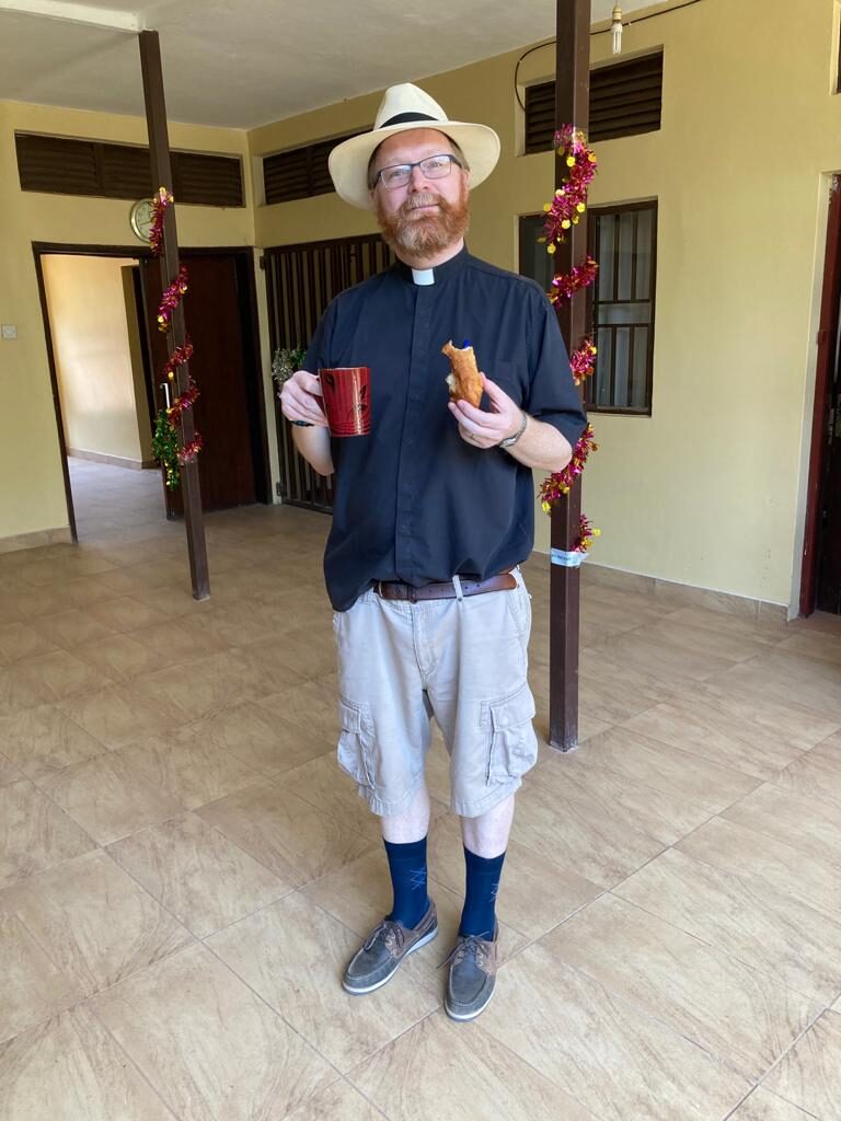 Fr Alan enjoying a mandazi 